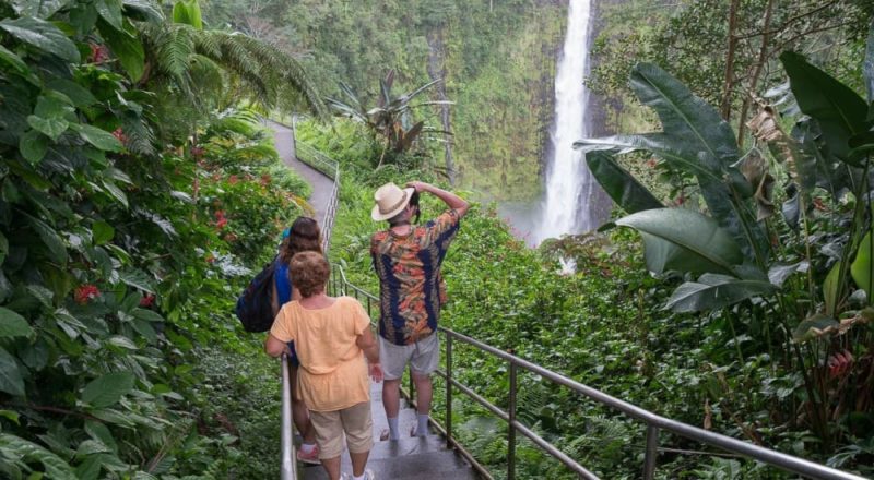 Visitors photographing 442-foot ʻAkaka Falls on the circle island tour