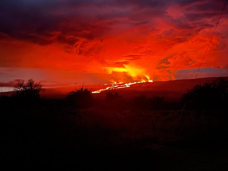 Photograph taken from Saddle Road at 6AM Hawaii time on November 29, 2022 shows lava flows moving northeast downslope of Mauna Loa volcano from the Northeast Rift Zone eruption.