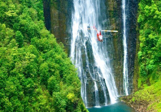 waterfall on hawaii with helicopter