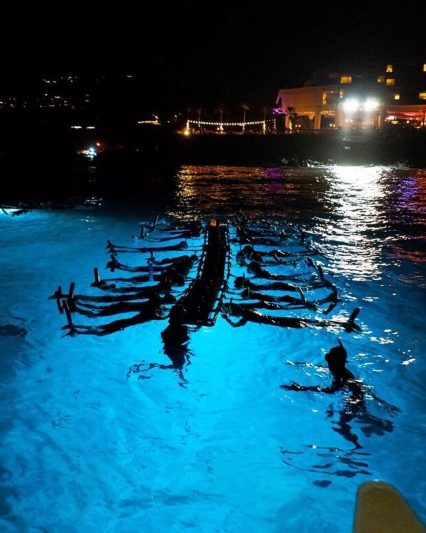 You will hold on to a flotation device with attached lights that attract manta rays close to the raft.