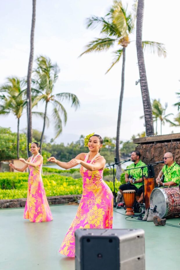 Two women performing Polynesian dance to live music at the Sunset Luau, Waikoloa Beach Marriott, Big Island