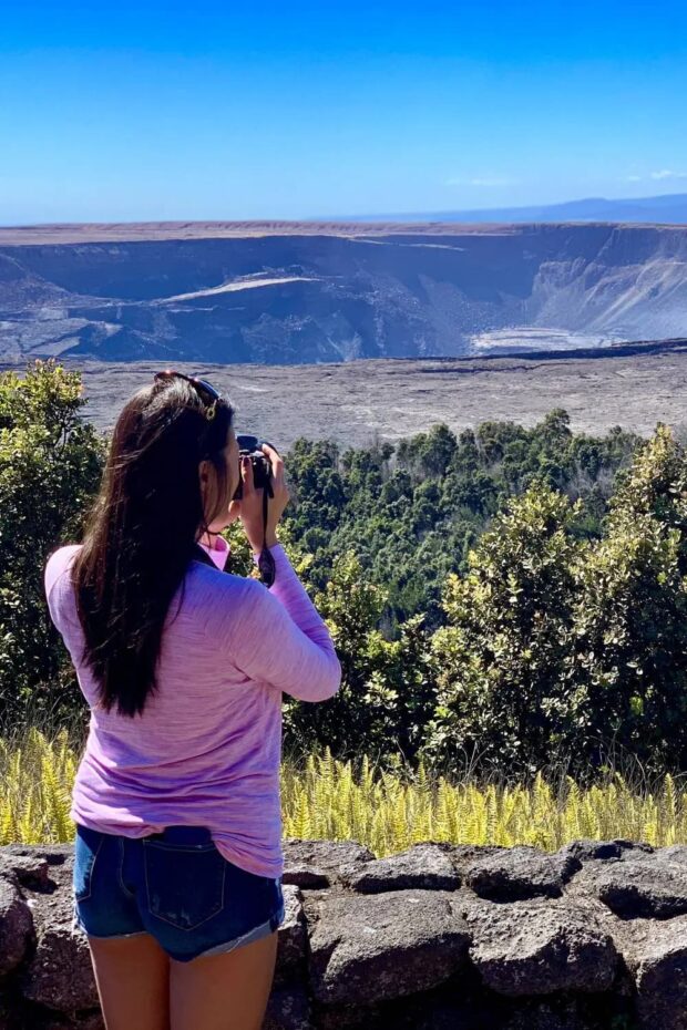 Tour guest photographing Halemaʻumaʻu crater in Hawaiʻi Volcanoes National Park