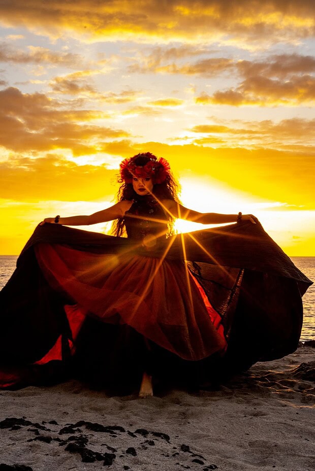 Single hula dancer silhouetted against the setting sun