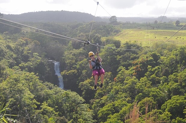 Zipline rider above Kamaʻeʻe Falls on the Botanical World Adventures course, Hamakua Coast