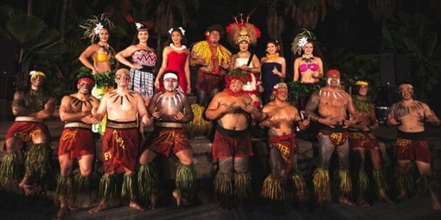 Full cast of Chief's Luau performers posed on stage at night