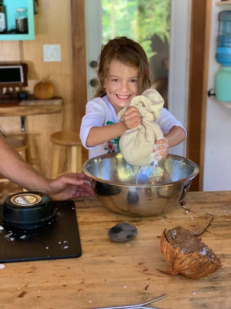 little girl making coconut cream during cooking class