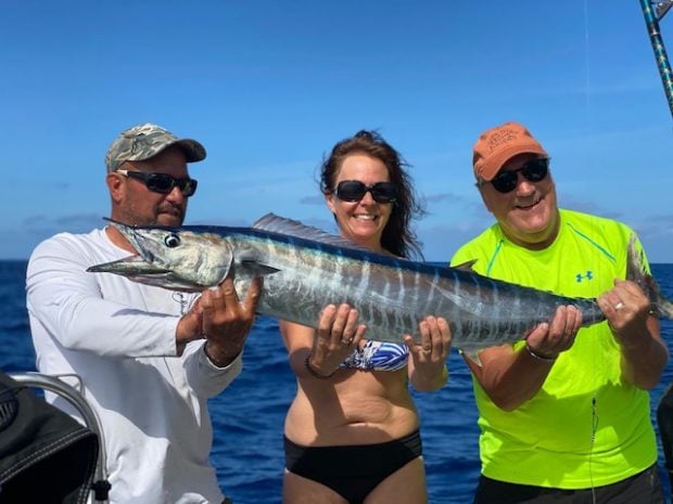 3 people holding a fish