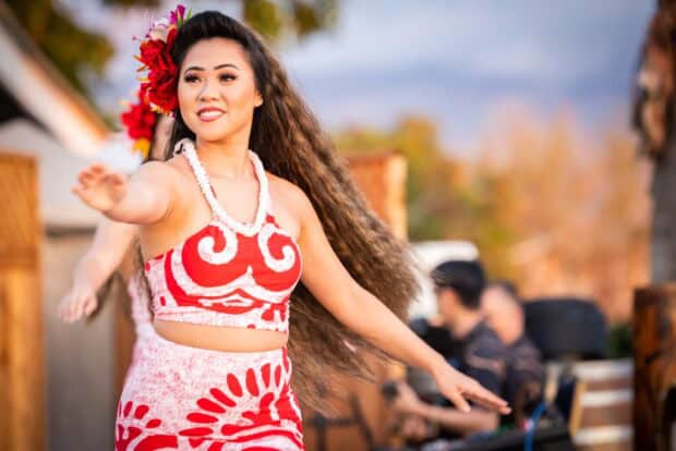 Tahitian dancer in a red tapa-print costume performing at Gilligan's Island Luau in Kīhei, Maui