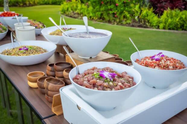Bowls of ahi poke and lomi lomi salmon on the buffet table at the Grand Hyatt Kauaʻi lūʻau