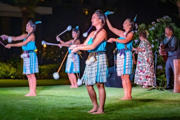 Dancers in blue costumes swing poi balls during the Māori section of the Grand Hyatt Kauaʻi lūʻau