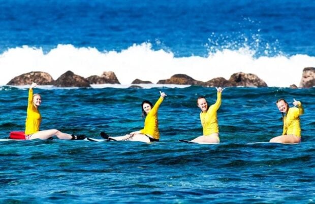 4 girls taking a surfing lesson in Kona.