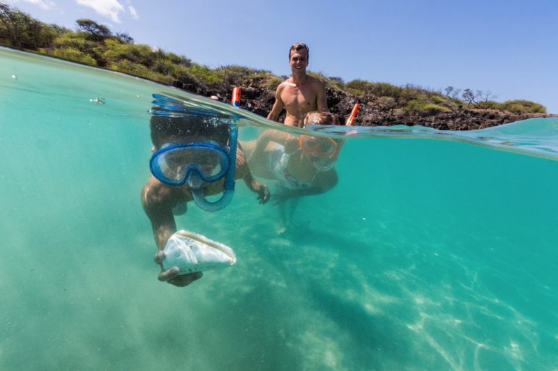  Child finds shell while snorkeling at Hapuna