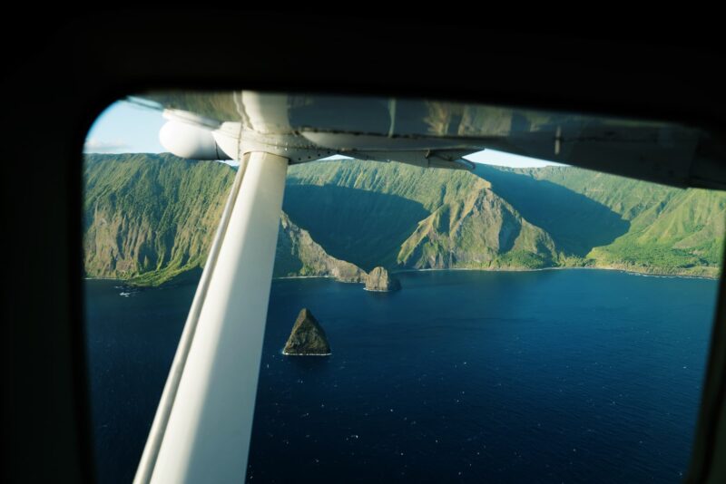 A view of the North Molokai cliffs through a small airplane window