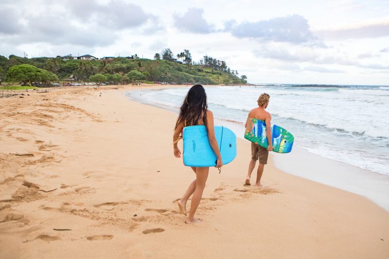  Couple head out to bodyboard in Kealia, Kauai 