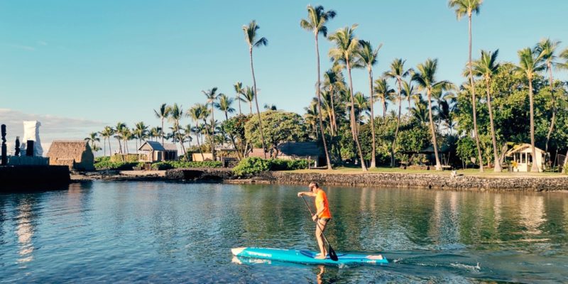 a stand-up paddle boarder is heading out into Kailua Bay.