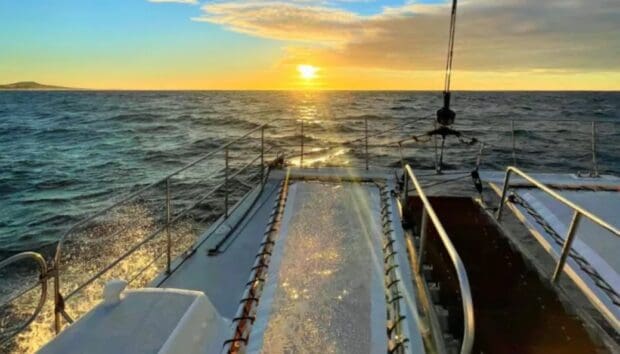 View forward from the bow of the Kona Style sailing catamaran as the sun sets off Kailua-Kona