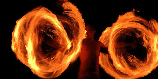 Fire knife dancer performing at the Mauna Kea Luau at dusk, Mauna Kea Beach Hotel, Big Island Hawaii