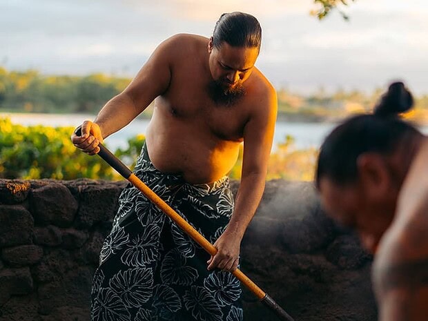 Imu ceremony at the Mauna Kea Luau, staff uncovering the underground oven, Big Island Hawaii