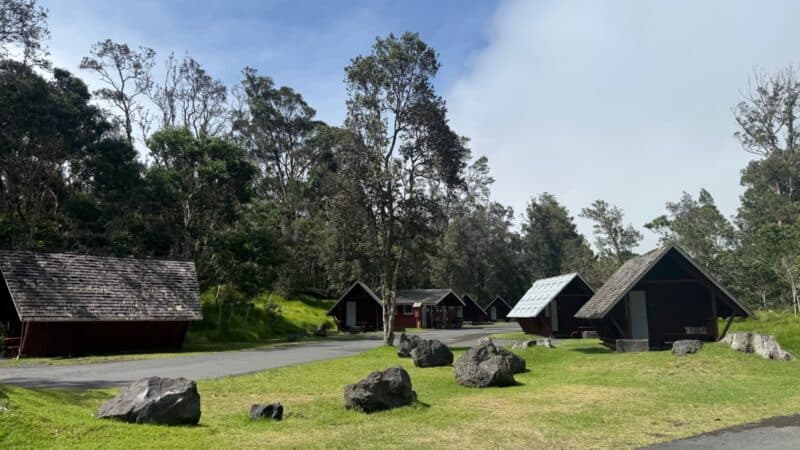 Row of red A-frame camper cabins on the lawn at Nāmakanipaio in Hawaiʻi Volcanoes National Park