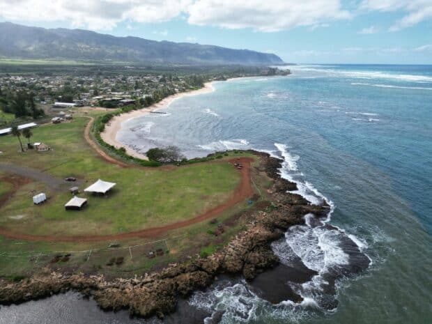 Aerial view of the oceanfront farm loop trail and rocky shoreline at North Shore Stables in Waialua