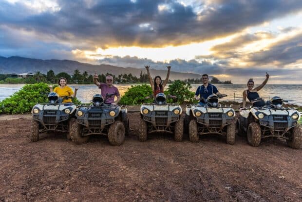 Riders on ATVs at sunset by the ocean at North Shore Stables in Waialua, Oʻahu
