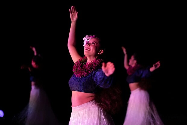 Three hula dancers mid-performance on stage