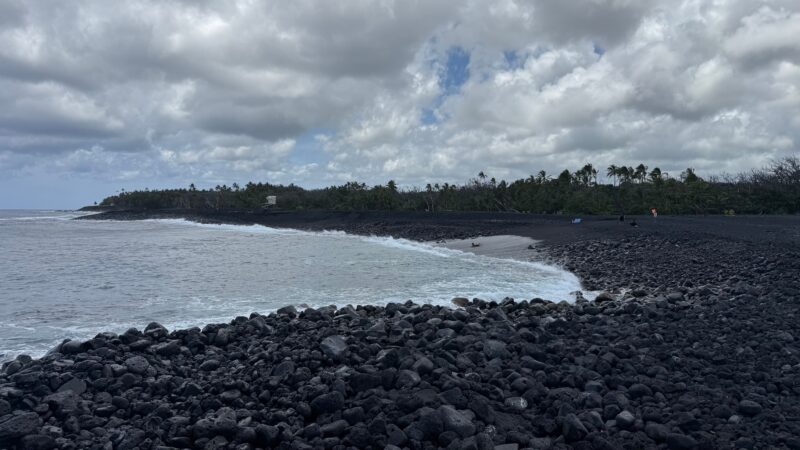 Large lava boulders at the waterline at Pohoiki black sand beach, making ocean entry hazardous, Big Island