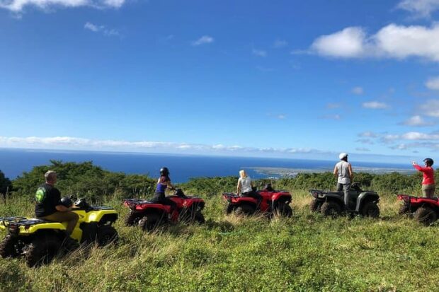 Group of ATV riders paused on a hillside overlooking the Pacific on the Polynesian Cultural tour at Aloha Adventure Farms