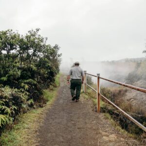 Park ranger walks along trail near steam vents