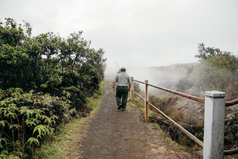 Park ranger walks along trail near steam vents 