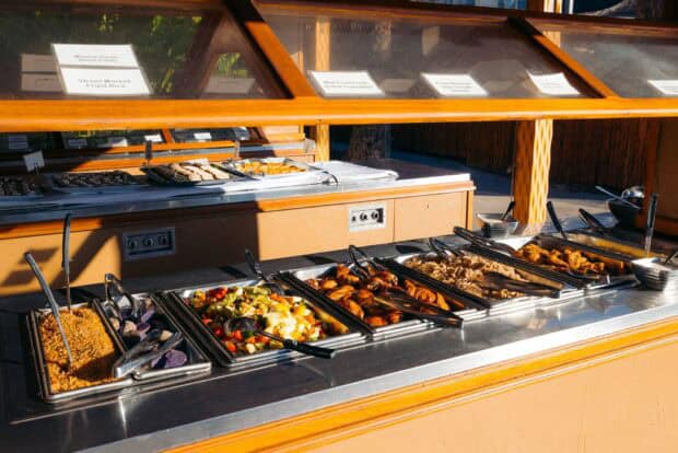 Buffet trays of teriyaki chicken, kālua pork, fried rice, and vegetables at the Myths of Maui Luau