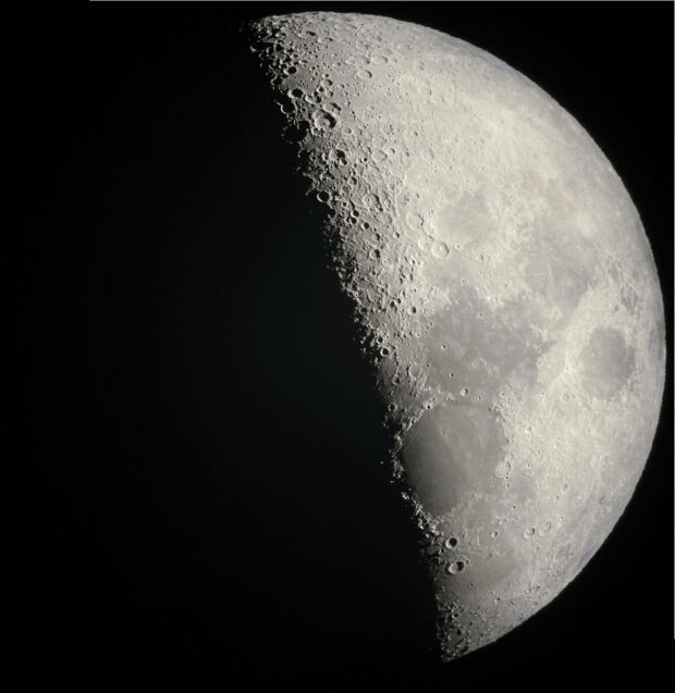 Half moon with its craters in sharp detail, seen through a telescope at the Ko Olina star show