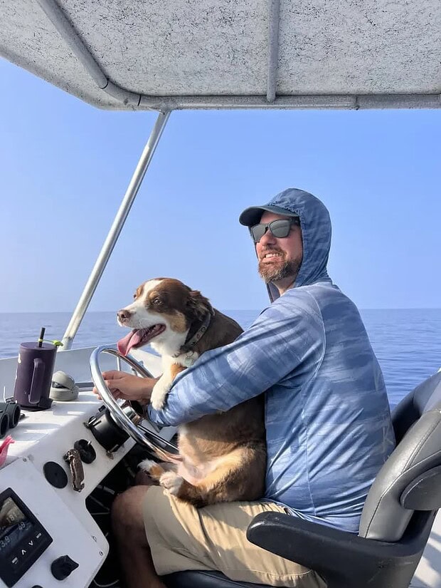 Torpedo Tours dive instructor and USCG captain Michael Hale with crew dog Cieba, a mini Australian shepherd, at Honokōhau Harbor