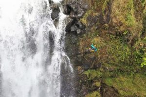 person rappelling down a waterfall on Hawaiʻi