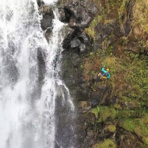 person rappelling down a waterfall on Hawaiʻi
