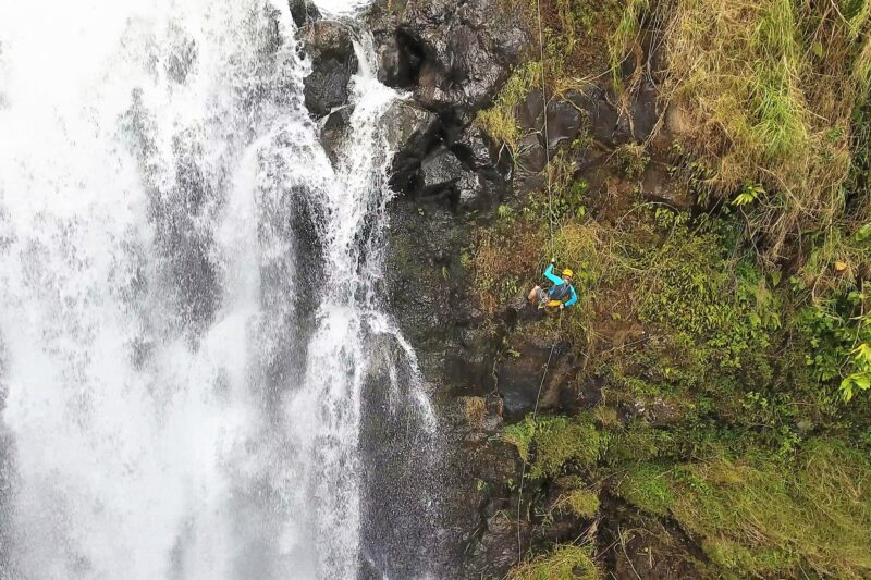 person rappelling down a waterfall on Hawaiʻi