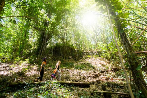 Two women walking the trail to the waterfall on the Kauaʻi UTV tour at Kipu Ranch