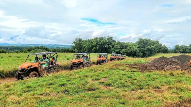Line of six Kawasaki UTVs parked in an open field on the Kauaʻi ranch tour